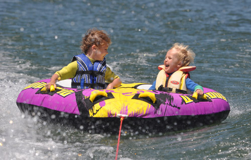 Kids riding a Ski Biscuit on Lake Dunstan, Central Otago, New Zealand